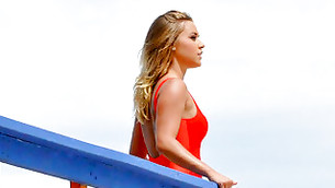 Extremely ardent bimbo standing outdoors in her red swimming suit looking gorgeous